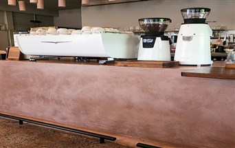 FF MicroCement wall finish at a contemporary café in Surat, showcasing seamless, matte-textured surfaces.